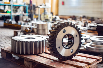 Two large gears after heat treatment lie on a wooden rack. Gear cutting and milling in heavy...
