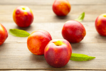 Many fresh nectarines on grey wooden background