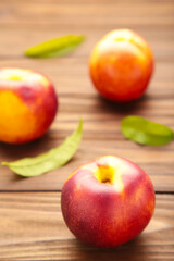 Many nectarines on brown wooden background. Vertical foto