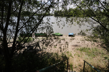 Pedalos, or paddle boats, on the shore of the Danube River, in Romania, on a sandy beach.