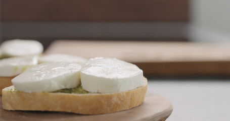 bruschetta with pesto and mozzarella on olive board