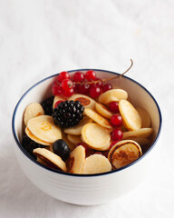 Tiny pancakes with berries in close-up on a white tablecloth. The concept of Breakfast trends in the supply. Copy space
