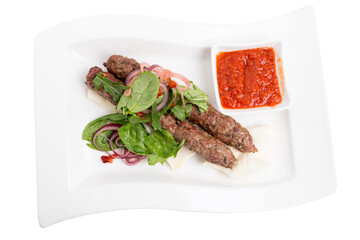 Beef kebab with spicy tomato sauce on skewers.