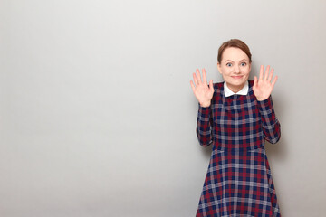 Portrait of happy overjoyed girl raising hands up in triumph