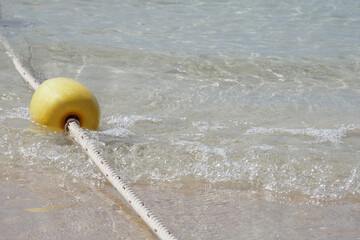 Naklejka premium Yellow buoy is a channel buoy in the sea with rope boundary line To be a swimming area for tourists