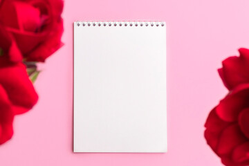 Above view of blank paper notepad with flower frame