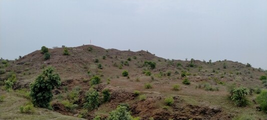 Mountain hill with less trees and blue sky