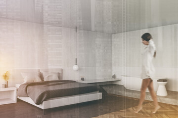 Fototapeta na wymiar Woman walking in white bedroom with bathtub