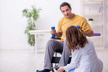 Young male patient in wheel-chair doing physical exercises