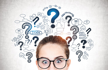 Astonished teen girl in glasses, question marks