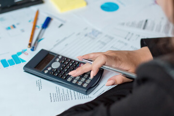 Businesswoman using a calculator to calculate the numbers