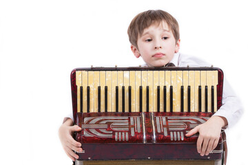 Child with a musical instrument. Elementary age boy with an accordion.