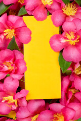 Yellow cosmetic box on pink flowers. Blank card.