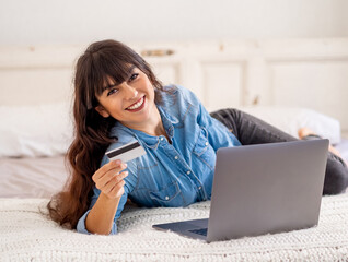 Woman using laptop and credit card online shopping during coronavirus lockdown and social distancing