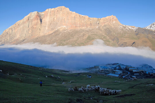 Above clouds. Kurush village (the southernmost point of Russia and the highest mountain settlement in Europe, 2560 m) and Erydag mountain (3925 m). Dagestan, North Caucasus, Russia.