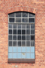 Altes Fenster mit Backsteinwand an einem Hafenschuppen