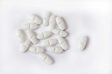 Fototapeta na wymiar White pills on a white background close-up. Painkillers. A remedy for the Covid19 virus. Tablet macro. Copy space.