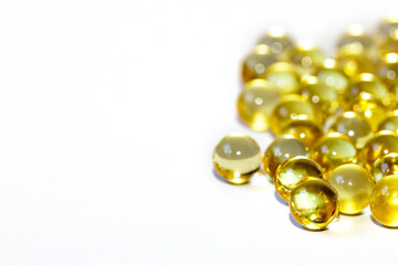 Yellow fish oil in capsules on a white background. Omega3 vitamins close-up. Capsules fish oil macro. Vitamins for health.