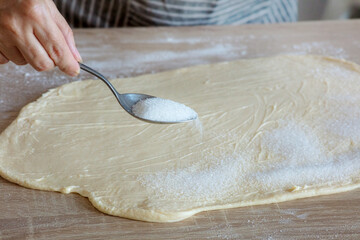 sugar is poured on the yeast dough