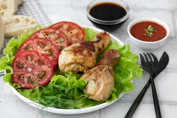 crispy fried chicken drumsticks with fresh tomatoes and lettuce
