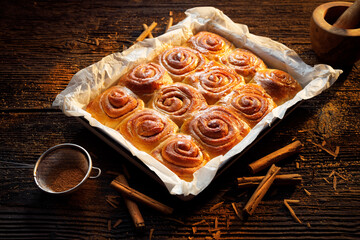 Homemade cinnamon sweet buns on a wooden  rustic table, top view