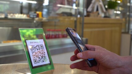 Smartphone scanning the recipient’s QR code. Mobile banking. Customers can pay through QR code,...