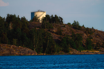 An old and decommissioned oil tank standing on the top of a cliff photographed during sunny summer...