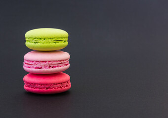 Colorful macarons on black background.