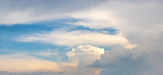 Blue sky with white clouds of different shapes during sunset