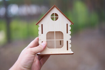 Miniature wooden house male hand outdoor nature. Real estate concept. Modern housing. Eco-friendly energy efficient house. Buying home outside the city Fresh air.