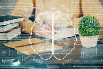 Multi exposure of writing hand on background with brain hologram. Concept of learning.