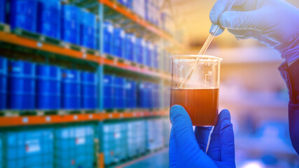 Jar with dark liquid in the hands of a laboratory assistant. Concept - refining industry. Chemist...