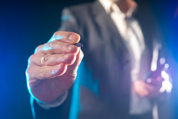 Pressing the stylus on the screen. Concept - a man presses the stylus on camera. Place for a button. Concept - businessman makes a choice. Man points to the camera. Businessman on a dark background