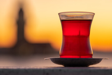 Traditional turkish tea in a glass with Maiden Tower at background in Istanbul, Turkey