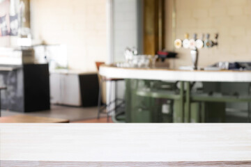 Empty wooden desk space and blurry background of pub or bar club for product display montage.