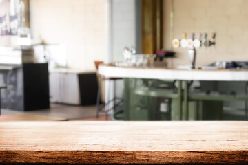 Empty wooden desk space and blurry background of pub or bar club for product display montage.