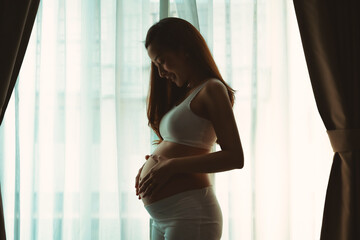 Asian teen beautiful in Pregnancy 20 week posing relex smile in bedroom her by touch cute pregnant...