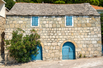 Fototapeta na wymiar Traditional stone house with blue door and window in Croatia