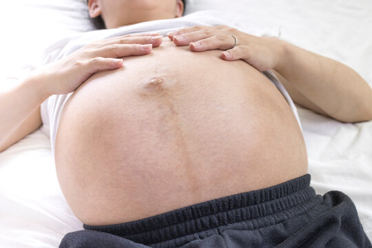 出産予定日の近い妊婦がベッドで横になる