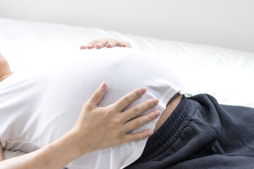 出産予定日の近い妊婦がベッドで横になる