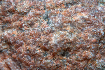 Blurred in soft focus background with the texture of the stone in warm, red tones.