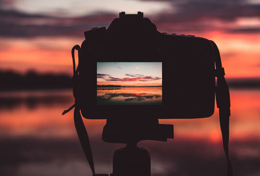 beautiful sunset over the lake. photographing a bloody sunset over a calm lake. camera on a tripod