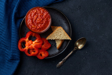 Aivar (spicy pepper sauce from the Balkans) in a bowl on a black background. Home cooked. Horizontal orientation