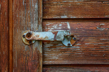 Old latch lock on a wooden door. Close-up.
