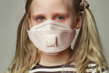 Child girl in protective medical mask crying, closeup portrait