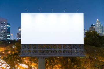 Blank white road billboard with Bangkok cityscape background at night time. Street advertising poster, mock up, 3D rendering. Front view. The concept of marketing communication to promote idea. © VideoFlow