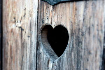 Heart shape at an old wooden door of a toilet