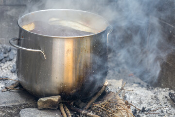 cooking outdoors, pot on wood fire in forest, picnic concept