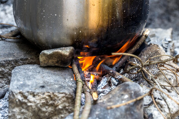 cooking outdoors, pot on wood fire in forest, picnic concept
