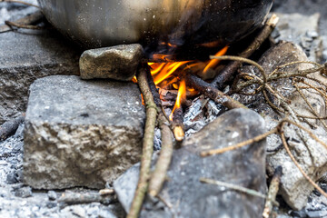 cooking outdoors, pot on wood fire in forest, picnic concept